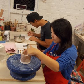 Two adults woring on handbuilding clay projects